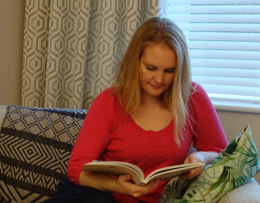 Julia Davies, aka The Simplicity Strategist, reads a book in her botanic geometric living room
